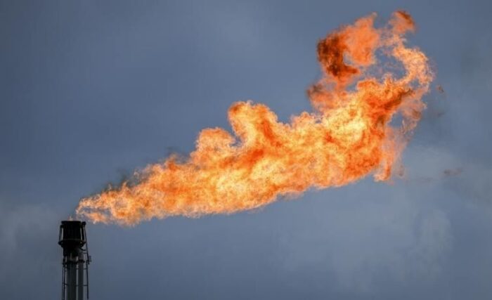 Large orange gas flare burning from an industrial stack