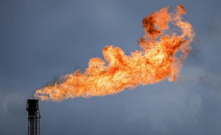 Large orange gas flare burning from an industrial stack